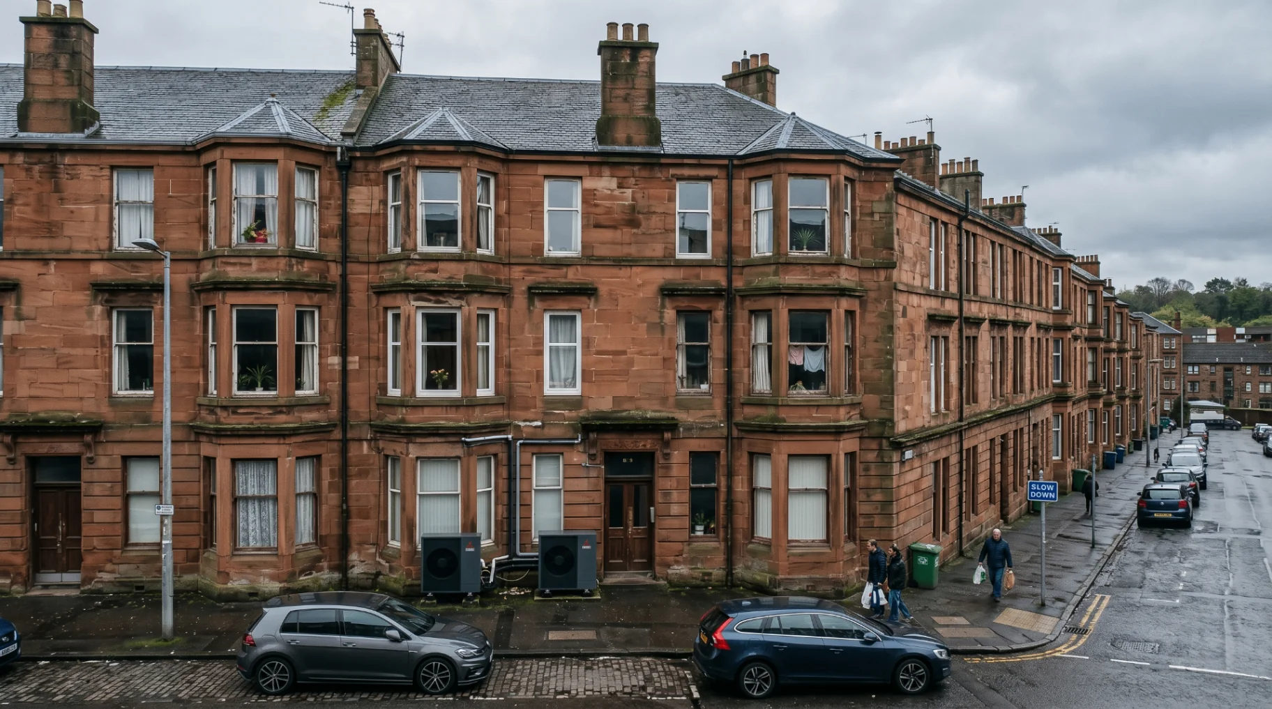 Row of traditional red sandstone Scottish tenement flats with air source heat pumps installed at ground level